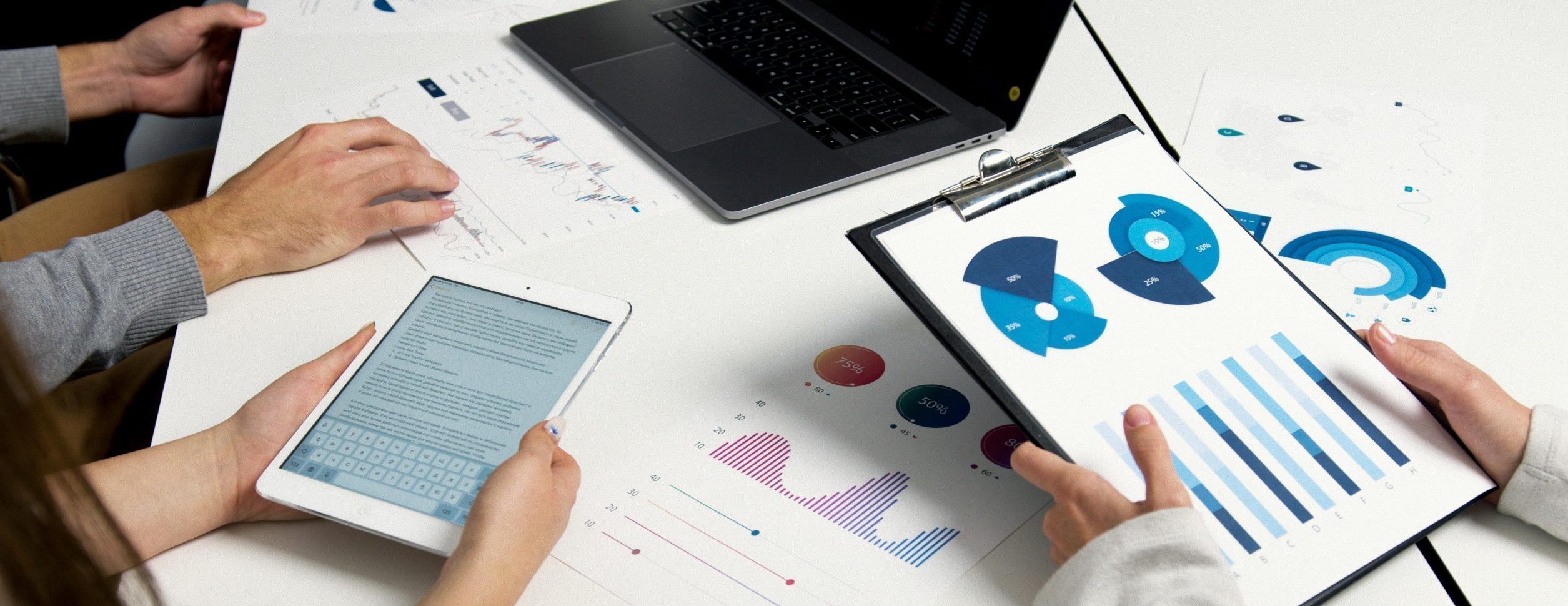 Team analyzing financial charts and digital reports during a business meeting.